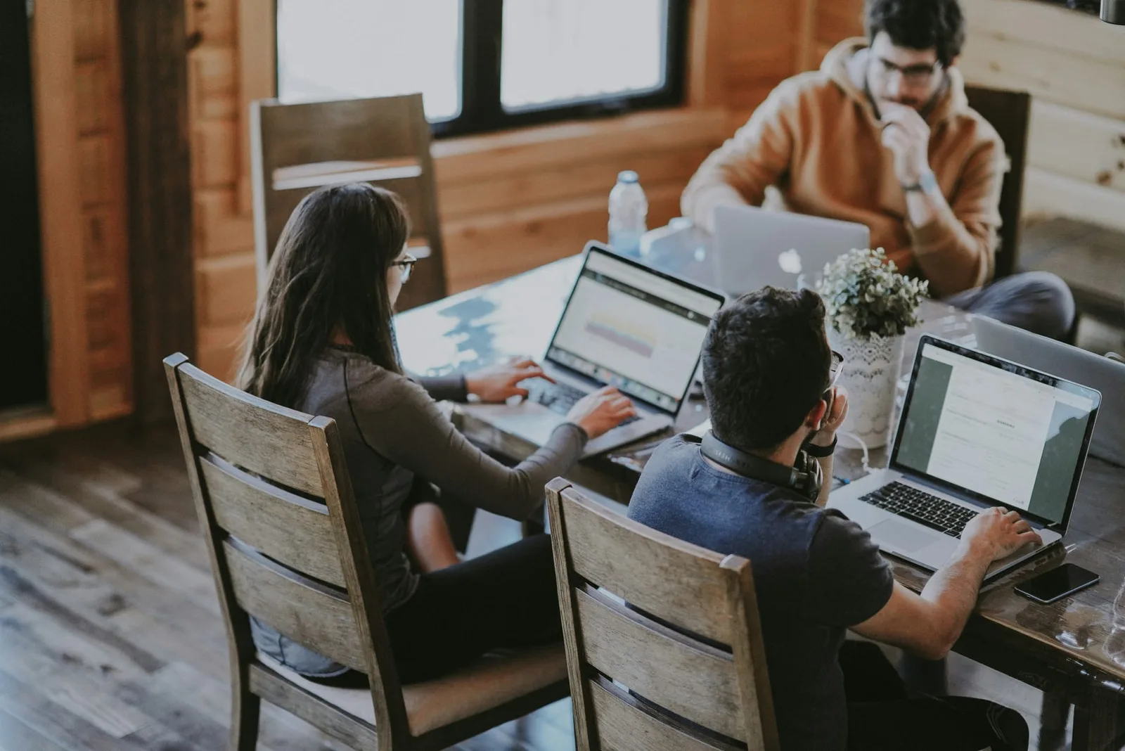 Freelances travaillant sur leurs ordinateurs portables dans un espace de coworking chaleureux
