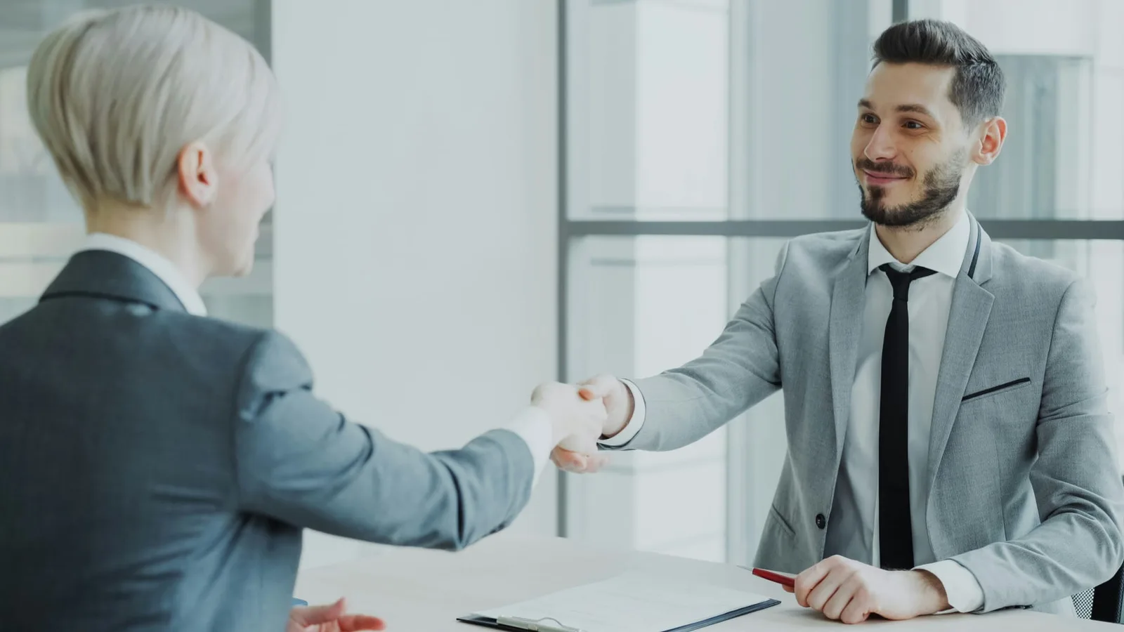 Poignée de main entre un consultant et sa conseillère lors de la signature du contrat